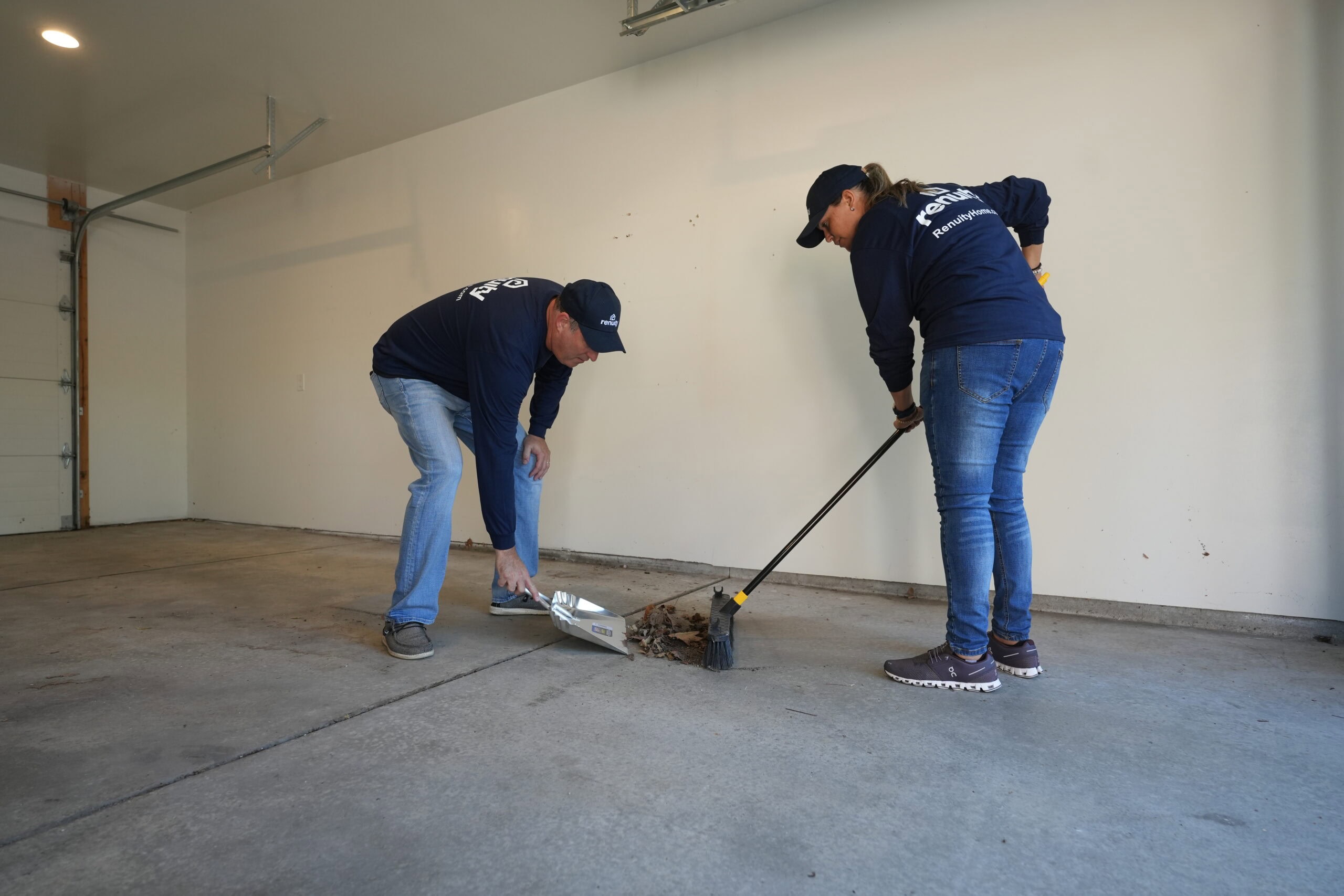 Two Renuity employees cleaning a garage