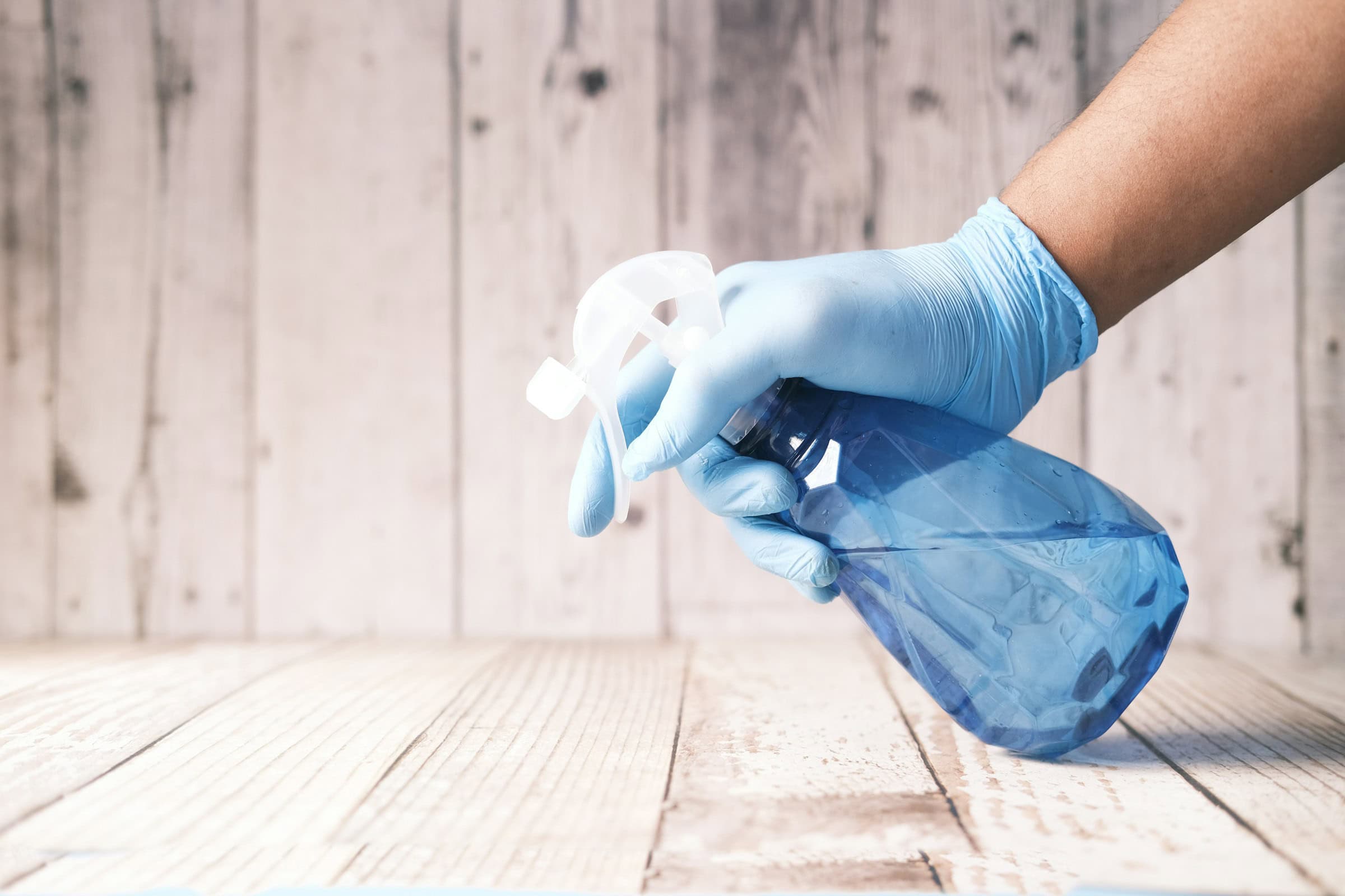 person using a spray bottle to clean the floor
