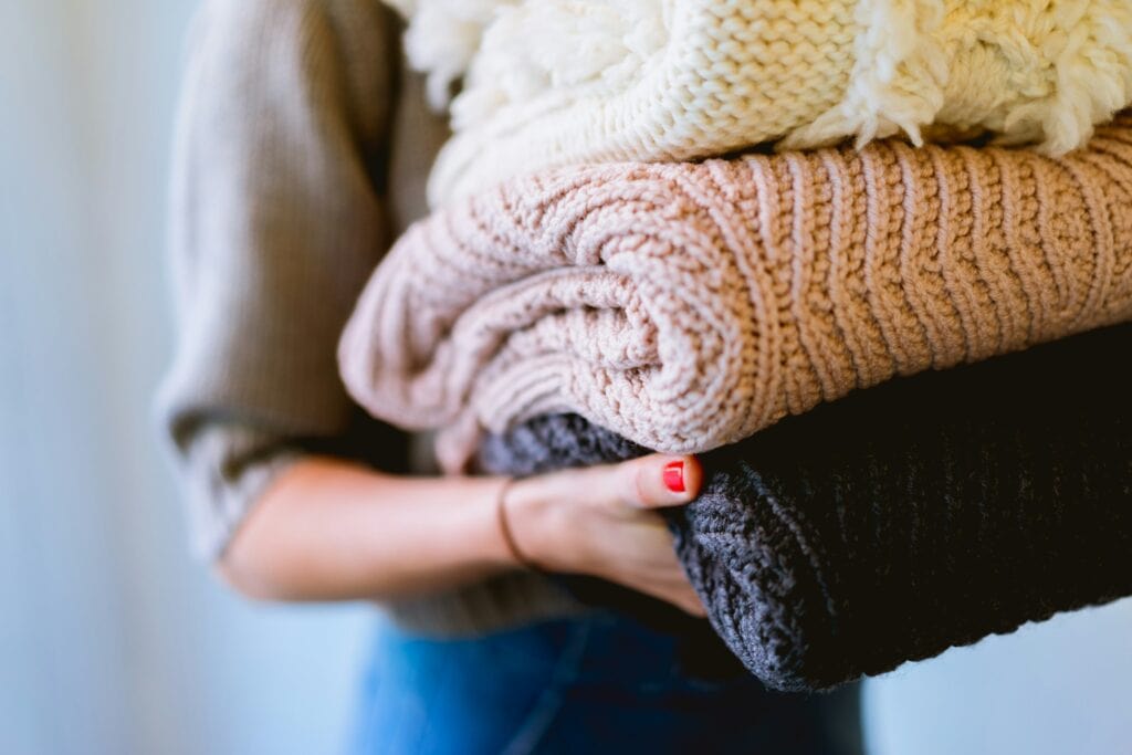 Woman holding a pile of clothing donations
