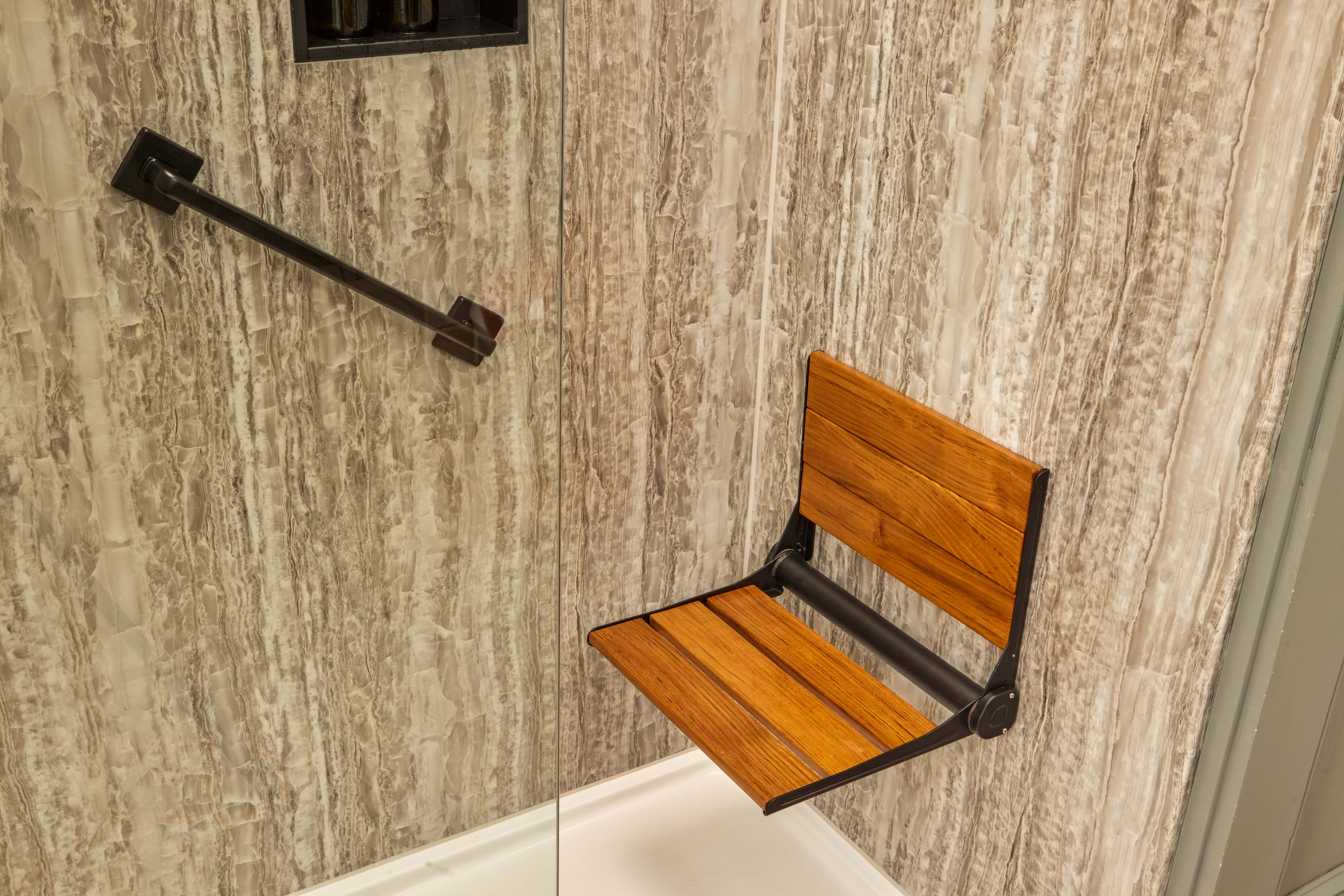 shower seat and grab bar|accessible bathroom|elderly woman getting out of bathtub