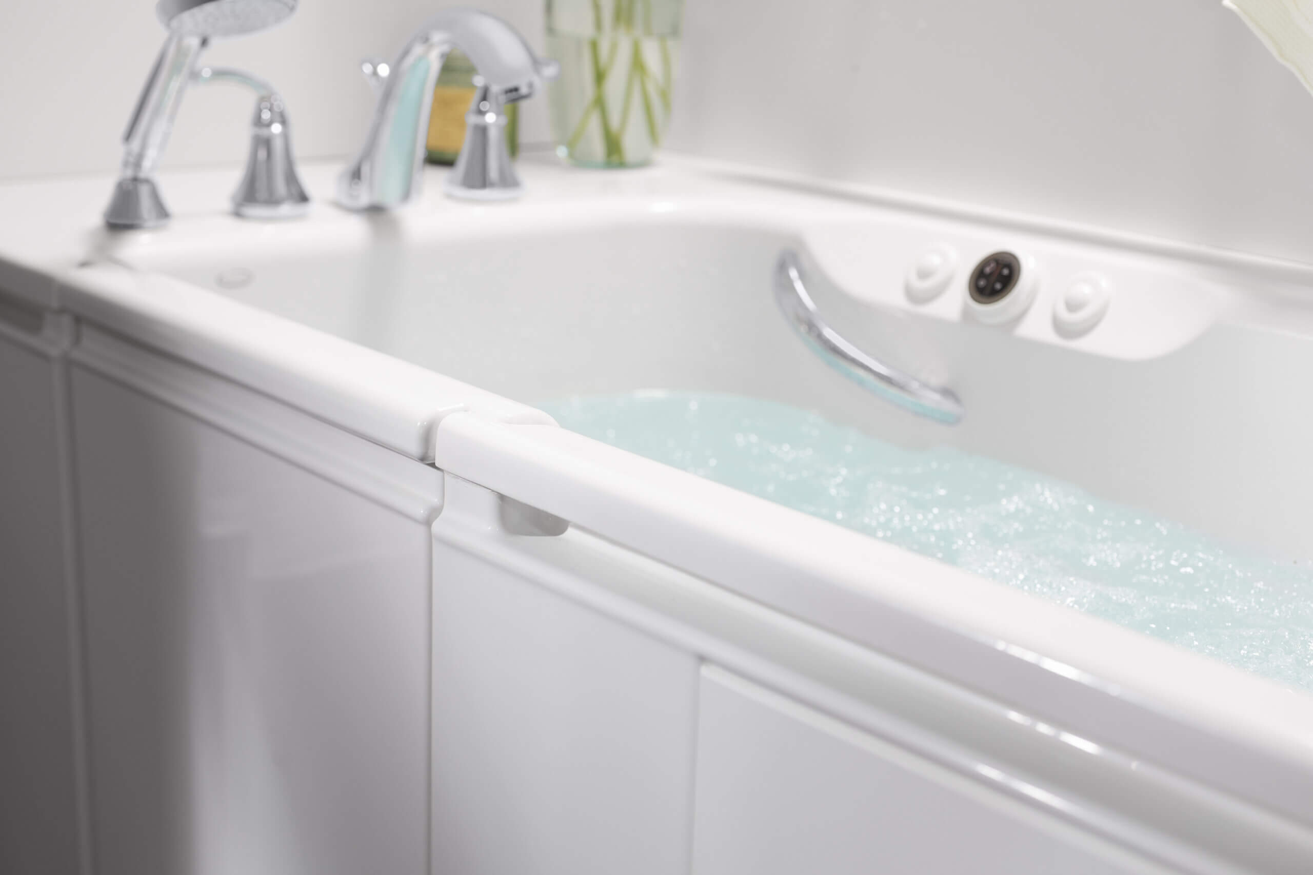 KOHLER walk-in bath|modern KOHLER walk-in bath|woman in a bathrobe entering a KOHLER walk-in bath|KOHLER walk-in bath witih LuxStone surround